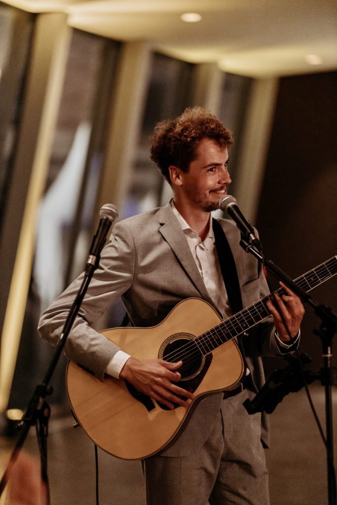 Hochzeitssänger Elias Tebroke spielt auf seiner Akustikgitarre
