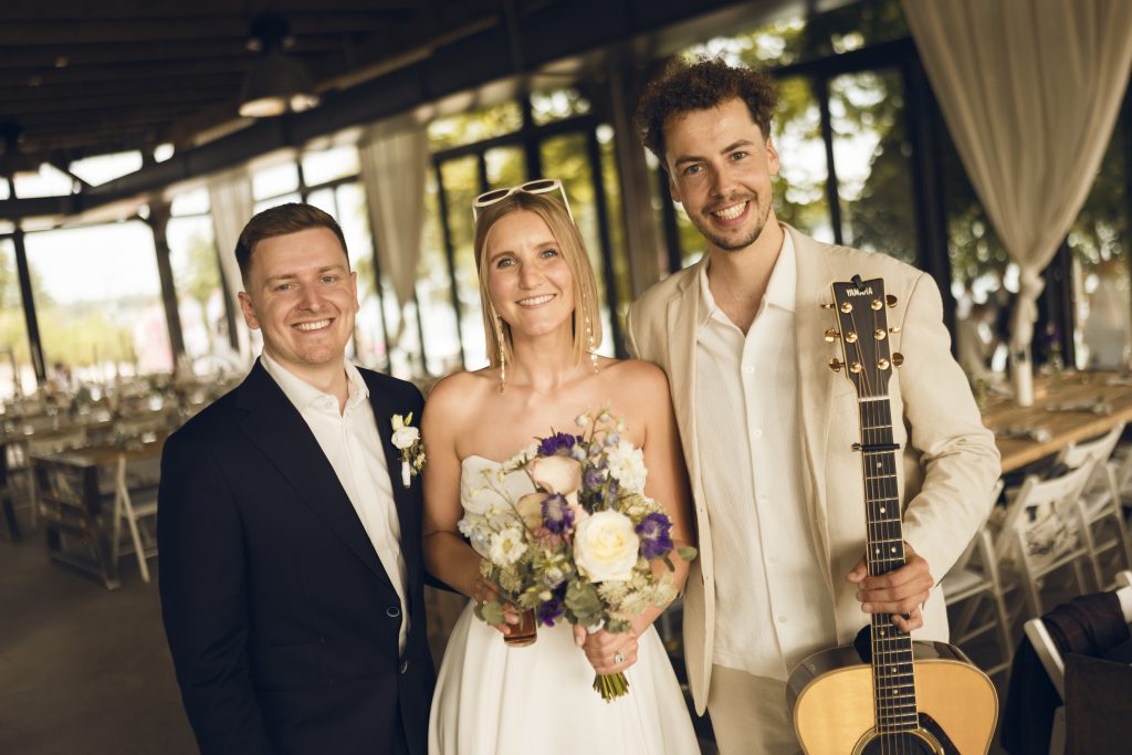 Hochzeitssänger Elias Tebroke mit Gitarre und glücklichem Brautpaar
